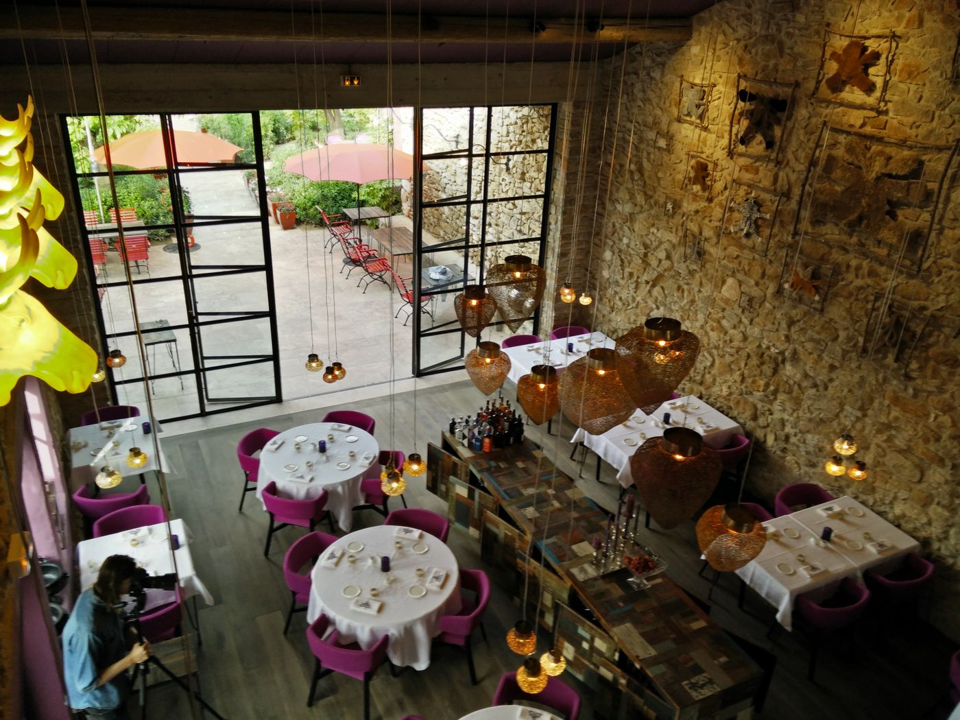 Éclairage domotisé d'une salle de restaurant en pierre, suspensions et ambiances programmées