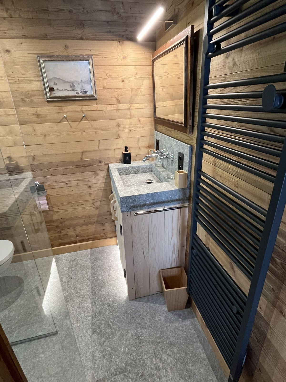 Salle de bain esprit chalet en bois : vasque en pierre, douche à l'italienne et sèche-serviettes